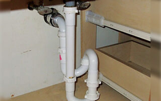 Plumbing Drainpipes under a sink should be simple: a small U-shaped bend called a “trap” holds a plug of water to prevent sewer gas from rising out of the drain.